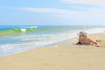 child boy lying sand beach baltic sea