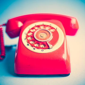 Vintage red telephone over blue background