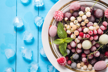 Frozen berry on turquoise background top view