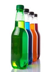 Multicolored soda drinks in bottles over white background