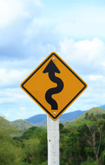 Winding road sign on blue sky