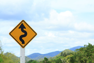 Winding road sign on blue sky