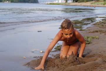 Fototapeta na wymiar Мальчик играет на пляже