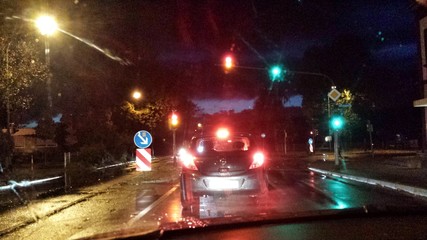Auto steht Nachts bei Regen an der Ampel - 71933890