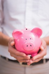 Mid section of man holding piggy bank