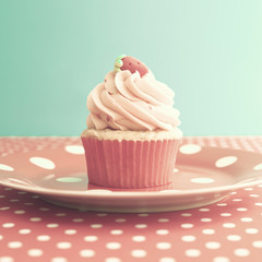 Strawberry cupcake over polka dots tablecloth