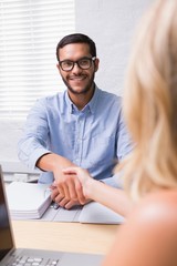 Businessman shaking hands with woman during interview