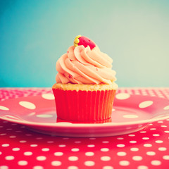Strawberry cupcake over polka dots tablecloth