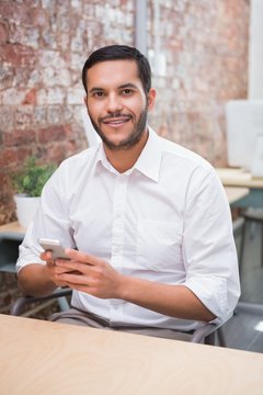 Businessman text messaging at desk