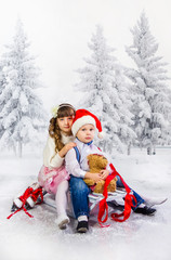 Children ride a sledge in the winter wood. Shooting in studio, a