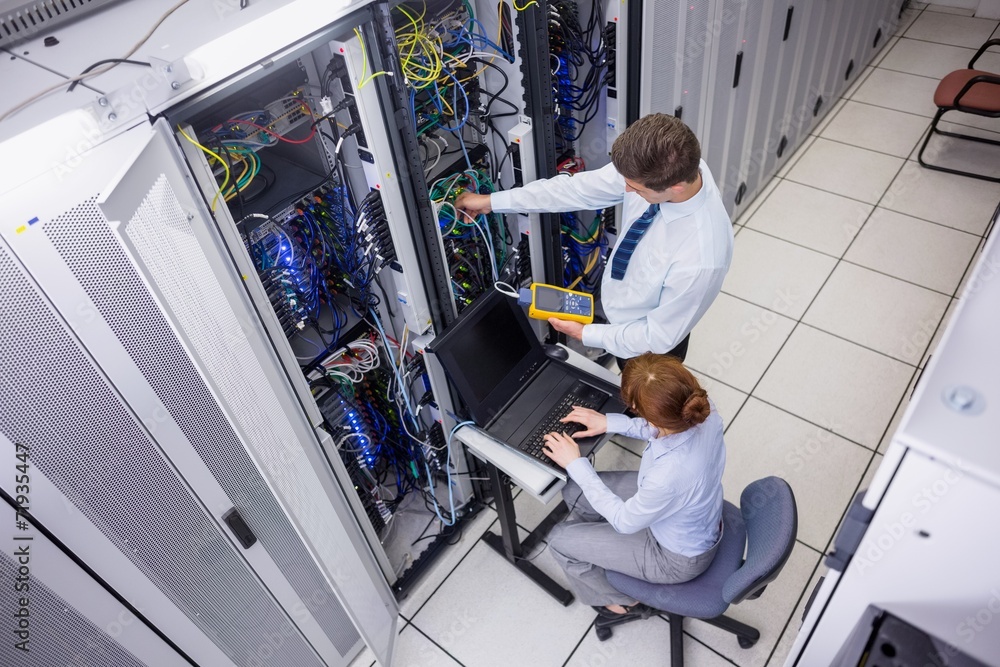 Aufkleber team of technicians using digital cable analyser on servers
