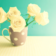 Vintage roses in a polka dots cup