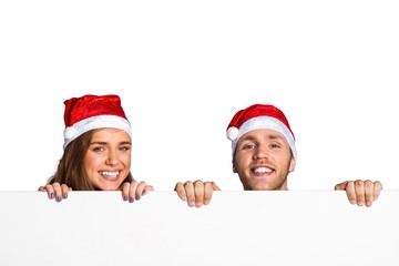 Couple in santas hats with blank board