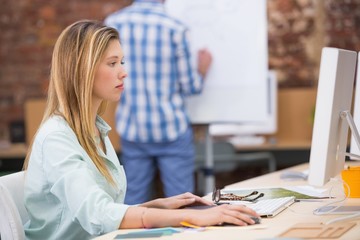 Concentrated female photo editor using computer in office