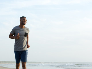 Active young man jogging at the beach