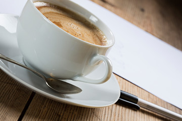 Person writing a letter with cup of coffee