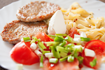 lunch plate with meatball, tomato, pasta and salad
