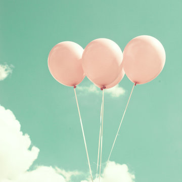 Four pink vintage balloons over blue sky