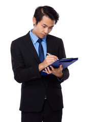 Businessman write on clipboard