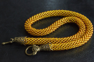 Necklace from yellow transparent beads against a dark background