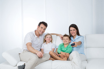 young family posing on sofa