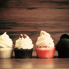 Vintage cupcakes over wood background