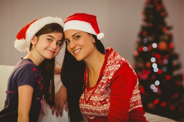 Festive mother and daughter smiling at camera