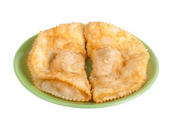 cheburek stuffed on a green plate isolated on white background
