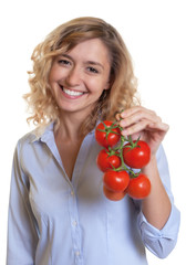 Frau mit blonden Locken liebt Tomaten