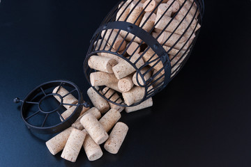 Fototapeta na wymiar Cork cage filled with blank wine corks lies on wooden surface
