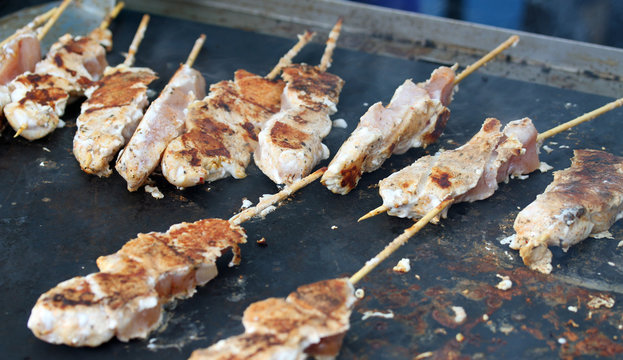 skewers of meat cooked on a griddle