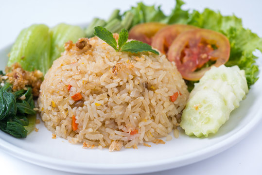 Rice and vegetables on a plate with a white background.