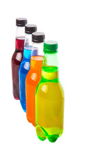 Multicolored soda drinks in bottles over white background
