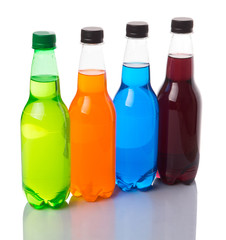 Multicolored soda drinks in bottles over white background