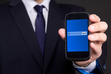 mobile phone with search bar on screen in business man hand