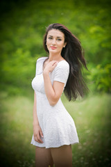 Beautiful young woman posing in a summer meadow