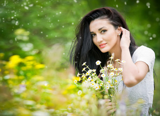 Beautiful young woman in wild flowers field