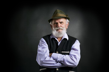 Old bavarian man in hat on black background - obrazy, fototapety, plakaty
