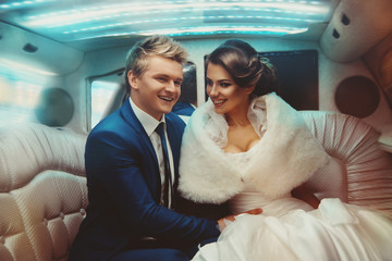 Lovely just merried couple driving in limousine - obrazy, fototapety, plakaty