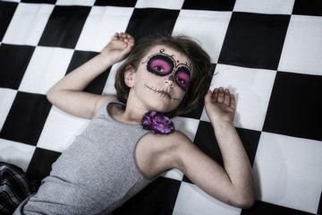jungles Mädchen mit Sugar Skull Make up liegt am Boden