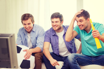 Fototapeta premium happy male friends with football and vuvuzela