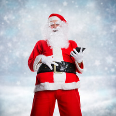 lachender Weihnachtsmann mit Tablet in Winterlandschaft