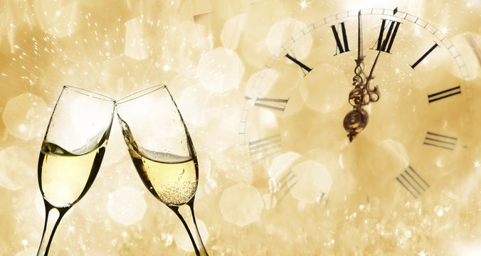 Glasses with champagne and clock close to midnight