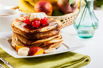 Pancakes with chocolate sauce fruit and coffee