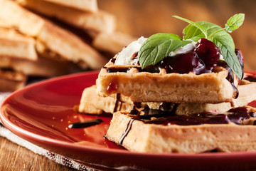 Waffles with chocolate sauce, whipped cream and confiture