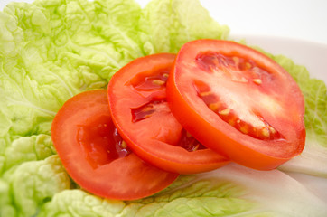 Red tomatoe slices on lettuce leaves