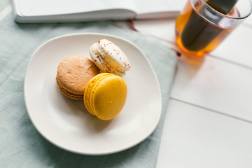Vintage toned photo of macarons on white wooden background