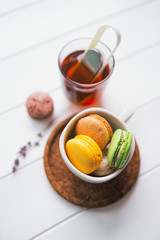Coloured macarons in cup on white with shallow depth of field