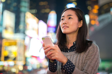Young Asian Woman texting cellphone at night