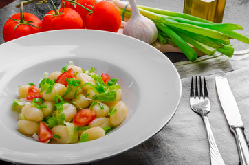 Vegetarian gnocchi with spring onions and tomatoes